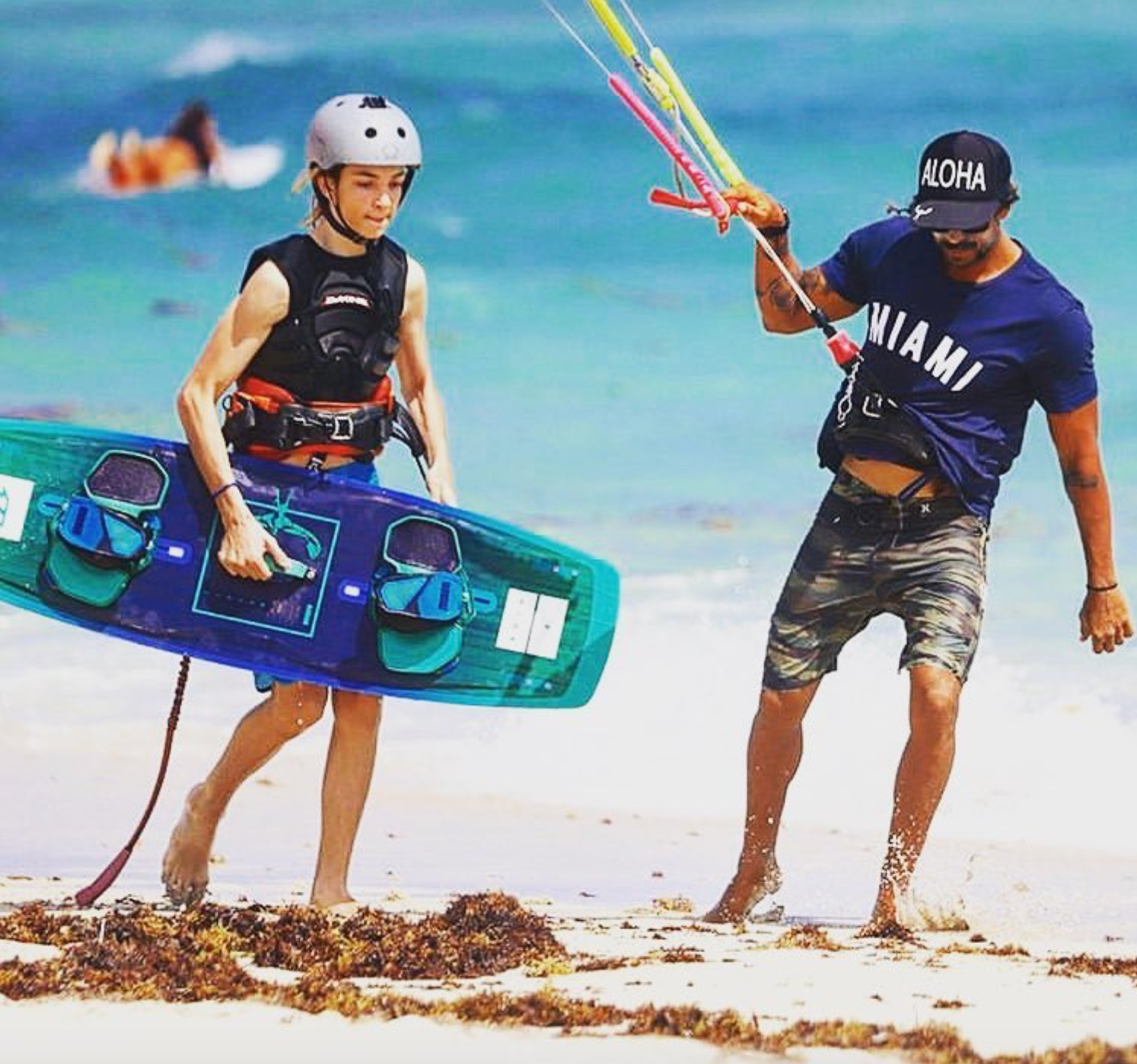 TKSMIAMI kite instructor with student walking kite on shoreline wearing safety gear 